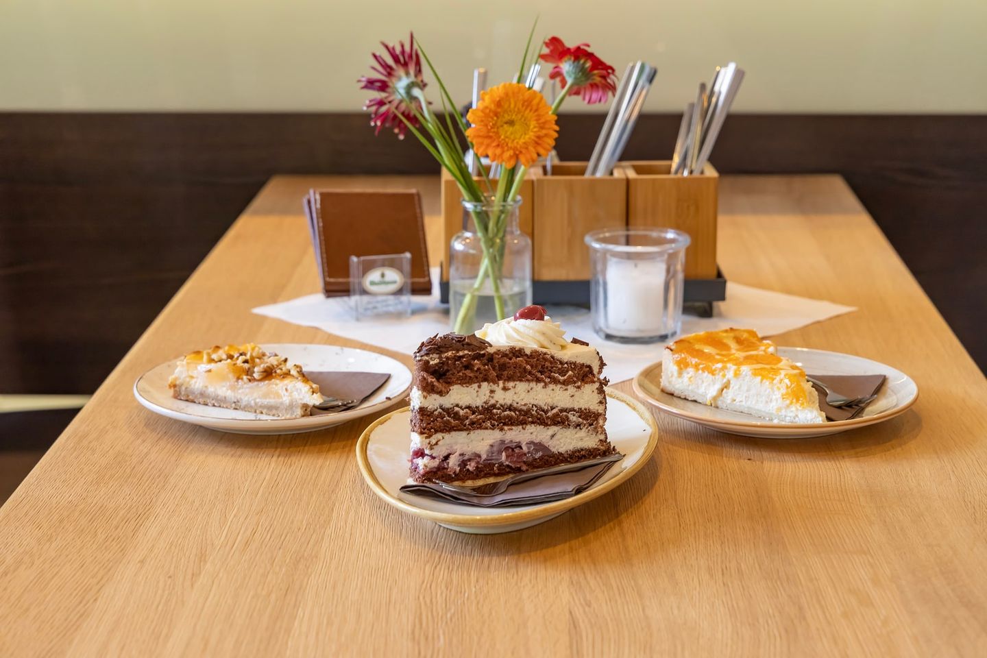 Drei Stücke Kuchen und Torte auf einem gedeckten Tisch in der Talstation